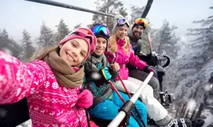 Rodzina na wyciągu narciarskim, ciesząca się zimową przygodą. Idealny stok narciarski mazowieckie czeka!