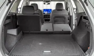 Wnętrze Škody Kodiaq z rozłożonymi siedzeniami. Duży bagażnik sugeruje przestronność, co jest kluczowe przy poznawaniu **Škoda Kodiaq wymiary**.