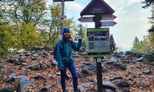 Kobieta na szczycie Łysica, 614 m n.p.m., przy drogowskazie. Jesienny szlak, liście i kamienie.