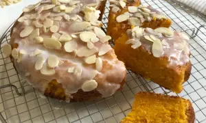 Torta carote mandorle e cioccolato, soffice e profumata, ricoperta da glassa e mandorle a lamelle.