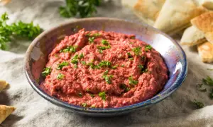 Pyszna pasta z czerwonej fasoli, posypana natką pietruszki, podana z kawałkami pity.