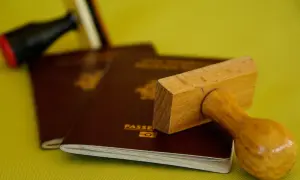 Pasporty i pieczątki, symbolizujące podróże, ale też potencjalną deportację.