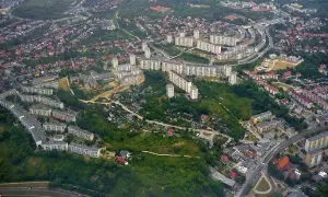 Widok z lotu ptaka na osiedle mieszkaniowe w Gdańsku Suchanino. Długie bloki mieszkalne otoczone zielenią i drzewami.