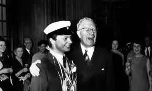 Kung Gustav VI Adolf ler glatt bredvid en student med studentmössa.