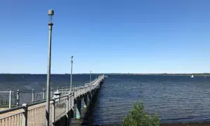 Langer Steg am Wismar Strand, der ins tiefblaue Wasser führt. Ein perfekter Ort für einen Spaziergang.