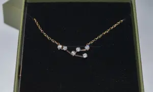 Colgante Tauro con circonitas brillantes en una caja verde.