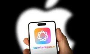 Dłoń trzyma iPhone'a z logo Apple Intelligence. Tło to rozmyte logo Apple.