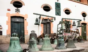 Antiche agnone campane della Pontificia Fonderia Marinelli, alcune appese, altre a terra, con un gatto curioso tra le più grandi.