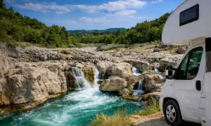 Wohnmobil am tosenden Wasserfall, ein wahres Naturwunder Deutschland. Türkises Wasser stürzt über Felsen, umgeben von grünen Hügeln.