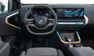 Interni moderni con volante, cruscotto digitale e ampio schermo per il sistema infotainment. Dettagli luminosi e finiture eleganti.