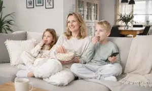 Rodzina ogląda film z popcornem. Idealny sposób na spędzenie 1 czerwca, dnia dziecka.
