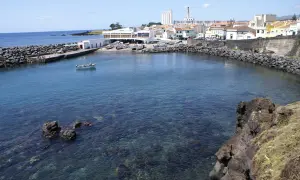 Malowniczy port na Azorach, idealne miejsce na wakacje. Woda jest krystalicznie czysta, widać łodzie i budynki.