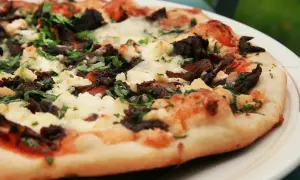 En härlig napolitansk pizza på grillen, med mörka svampar och krämig ost.