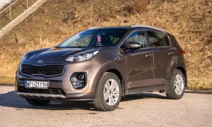 Brązowy Kia Sportage 2018 gotowy na przygodę. Elegancki SUV na tle słonecznego, suchego krajobrazu.