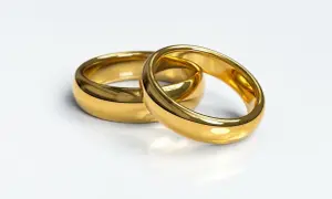 Dwa złote obrączki, symbol miłości. Zastanawiasz się, ile kosztuje gram złota 585 u jubilera?