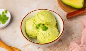 Un cremoso helado de aguacate, decorado con cilantro fresco, servido en un cuenco.