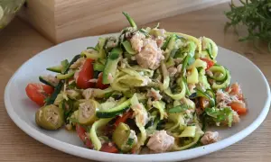 Deliziosa insalata di zucchine crude a spirale con tonno, pomodorini e olive verdi. Un piatto fresco e leggero.