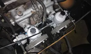 Detalle del motor de un coche clásico con doble carburador, listo para dar potencia.