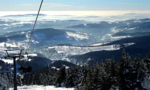 Blick vom Sessellift im Rokytnice Skigebiet auf verschneite Berge und Täler.