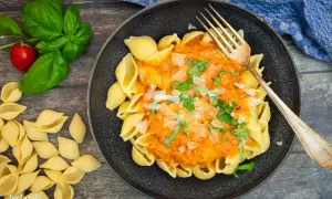 Schalen-Nudeln mit cremiger Tomaten-Sahne-Sauce, garniert mit Basilikum und Parmesan. Ein Genuss!