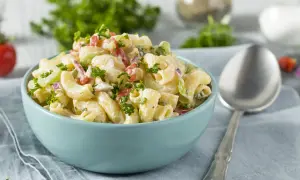 Cremiger Nudelsalat mit Joghurt, garniert mit frischer Petersilie. Perfekt für ein leichtes Mittagessen.