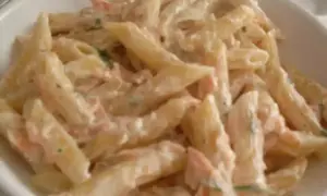 Penne cremose con salmone e panna, un piatto delizioso pronto per essere gustato.