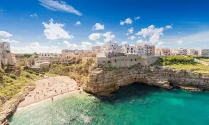 Un borgo bianco a picco sul mare turchese, una spiaggia incastonata tra le rocce. Un vero must-see in Puglia per chi ama panorami mozzafiato.