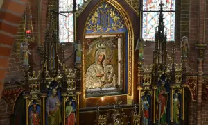 Ołtarz z obrazem Matki Boskiej, symbol objawień maryjnych w Polsce. Witraże i rzeźby dopełniają sakralny wystrój.