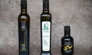 Tre bottiglie di olio extra vergine d'oliva, tra cui un Casaliva monocultivar e uno con etichetta "Le Creve Garda D.O.P.".