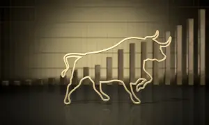 Złoty byk symbolizuje hossę, wzrosty na giełdzie. W tle wykres słupkowy pnący się w górę.