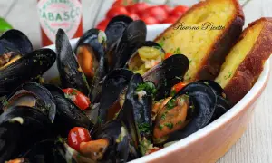 Sautè di cozze fumante, con pomodorini e pane tostato. Un piatto che profuma di mare e di casa.