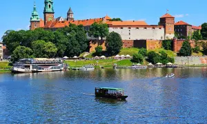 Krakau Sightseeing: Wawel-Schloss thront über dem Fluss mit Booten, die vorbeifahren.