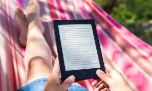 Osoba relaksuje się w hamaku, czytając e-booka. Idealny sposób na wakacje, gdy szukasz najlepszego czytnik ebook ranking.