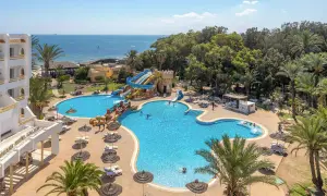 Basen z wodnymi zjeżdżalniami i palmami przy hotelu Marhaba Royal Salem.