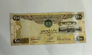 Banknot 200 dirhamów Zjednoczonych Emiratów Arabskich z wizerunkiem sokoła i budynków.