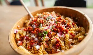 Pasta fredda da portare a lavoro, un'insalata colorata con fusilli, pomodori secchi, cipolla rossa e ravanelli. Perfetta per un pranzo gustoso.
