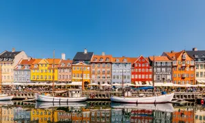 Bunte Häuser am Nyhavn, ein Kopenhagen must see. Boote spiegeln sich im Wasser.
