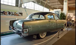 A vintage Volvo sedan, light green with a dark roof, is displayed indoors.