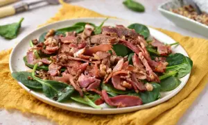 Sałatka szpinak z chrupiącym boczkiem i orzechami, polana sosem. Pyszne połączenie smaków.
