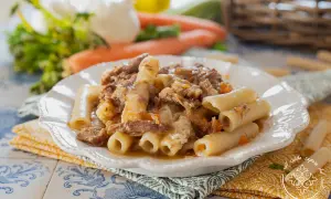 Piatto di ziti alla genovese con ragù di carne sfilacciata e verdure. Un classico della cucina napoletana.