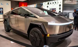 Futurystyczny Cybertruck Tesli błyszczy w salonie, gotowy na przygodę.