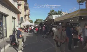 Festa San Crispino a Porto Sant'Elpidio: bancarelle affollate, gente che passeggia e acquista sotto un cielo azzurro.