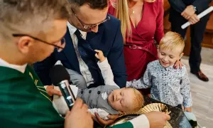 Chrzest dziecka w kościele, rodzice i ksiądz.