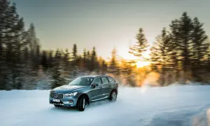 Volvo XC60 med d4 motor kör på snöig väg i solnedgången.