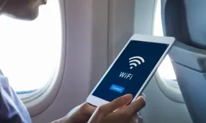 Osoba w samolocie sprawdza na tablecie, czy w Ryanair jest wifi. Widoczny ekran z ikoną wifi i przyciskiem "Connect".
