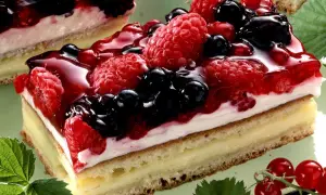 Ein saftiger **Beerenkuchen vom Blech** mit Himbeeren, Brombeeren und Blaubeeren, überzogen mit glänzendem Gelee.