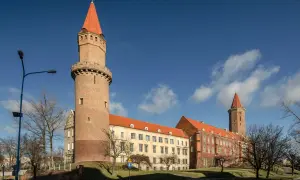 Zamek Piastowski w Legnicy, jedna z głównych atrakcji miasta, z charakterystyczną wieżą i czerwonym dachem.