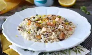 Un délicieux risotto fruits de mer crémeux, garni de zestes de citron et de persil frais.