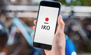 Dłoń trzyma smartfon z logo IKO. Dowiedz się, jak założyć IKO w telefonie, by wygodnie płacić.