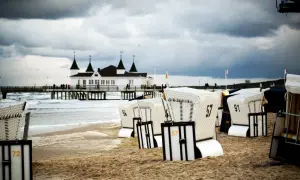 Strandkörbe am Ostseestrand mit Pier und Gebäude im Hintergrund. Perfekte ausflugsziele ostsee bei schlechtem wetter, um dem Wind zu trotzen.